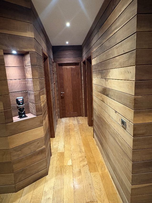 Pasillo revestido en madera con nicho iluminado