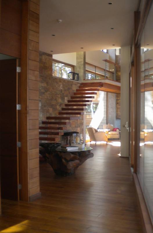 Escalera de peldaños de madera junto a muro de piedra