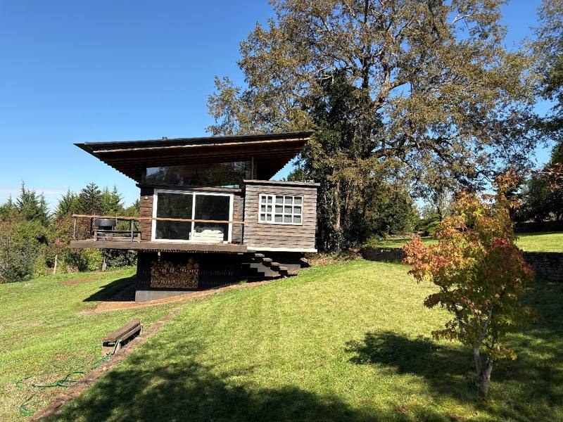 Casa Araucanía — Volumen de madera sobre la pradera, rodeado de árboles