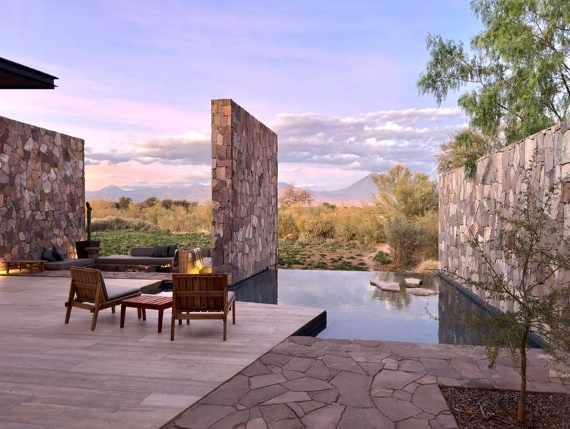 Hotel San Pedro de Atacama — Terraza con muros de piedra y piscina al atardecer