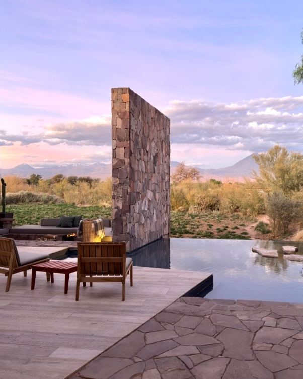 Hotel San Pedro de Atacama — Terraza con muros de piedra y piscina al atardecer