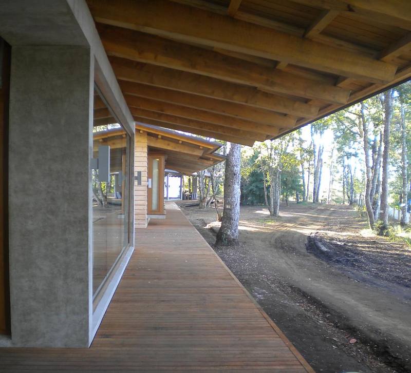 Lago Panguipulli — Pasarela de madera bajo el alero, junto a muro de hormigón arquitectónico