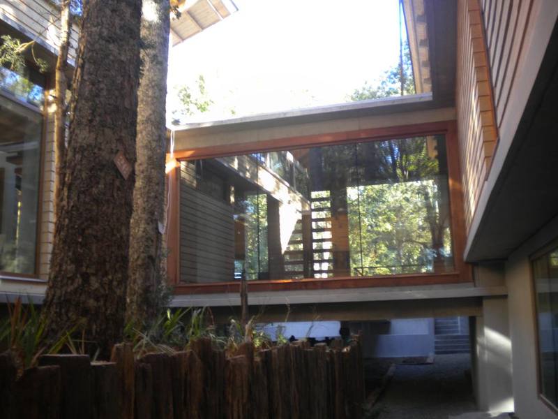 Lago Panguipulli — Patio interior con ventanales enmarcados en madera