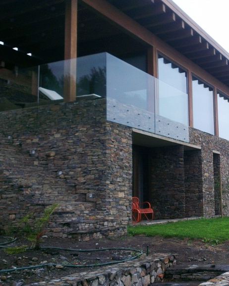 Lago Ranco I — Fachada de piedra con barandas de vidrio
