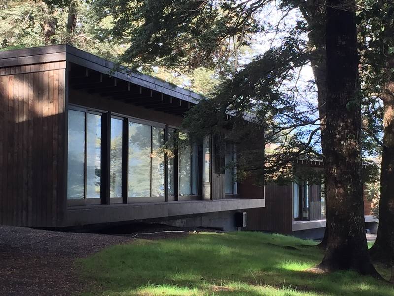 Lago Todos Los Santos II — Volumen revestido en madera oscura entre árboles